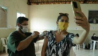 Mulher registra momento em que recebe dose da vacina na polo na Capital. (Foto: Kísie Ainoã)