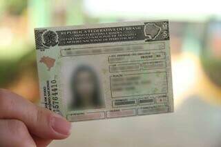 Mulher segurando Carteira Nacional de Habilitação. (Foto: Divulgação | Detran)