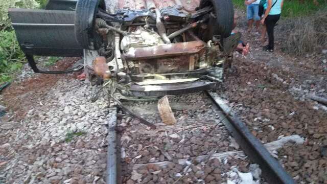 Homens ficam feridos ap&oacute;s carro capotar e cair em linha f&eacute;rrea na MS-450