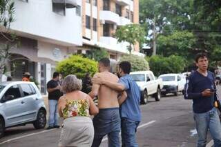 Funcionário que conseguiu sair sendo amparado por moradores enquanto chora. (Foto: Paulo Francis)
