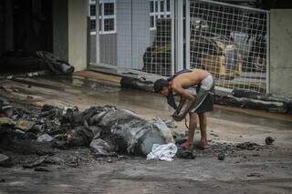 Rapaz vasculha escombros em busca de fios de cobre. (Foto: Marcos Maluf)