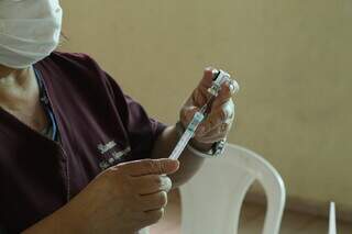 Vacina contra a covid-19 é preparada por vacinadora; imunizante reduz chance de casos graves da doença (Foto: Kísie Ainoã)