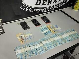 Celulares e dinheiro apreendidos com os suspeitos. (Foto: Mirian Machado)