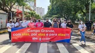 Servidores municipais com faixa pelo fim da violência contra mulheres. (Foto: Divulgação)