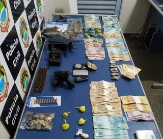 Dinheiro, drogas, arma e munições apreendidas. (Foto: Divulgação, PCMS)