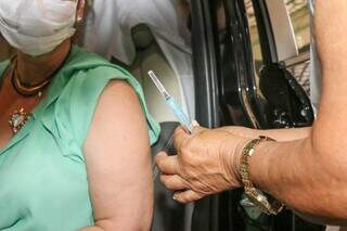 Mulher recebendo terceira dose em Campo Grande. (Foto: Henrique Kawaminami/Arquivo)