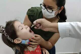 Criança recebe dose de vacina durante campanha em Campo Grande. (Foto: Divulgação)