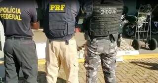 Policiais responsáveis pela apreensão em frente aos tabletes de cocaína. (Foto: Reprodução)