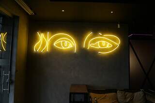 Decoração do bar com olhos da Monalisa em luzes neon. (Foto: Kísie Ainoã)
