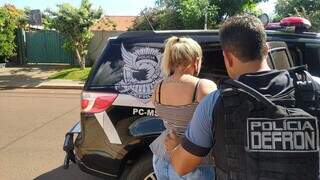 Ana Paula é levada para a viatura depois de ser presa em lojinha (Foto: Adilson Domingos)