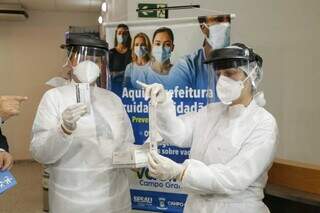 Servidoras da saúde com testes que serão disponibilizados no Aeroporto de Campo Grande. (Foto: Kísie Ainoã)