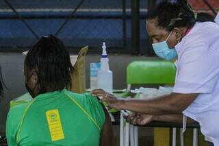 Estudante é vacinada contra a covid-19 na Escola Estadual Joaquim Murtinho, nesta manhã. (Foto: Marcos Maluf)
