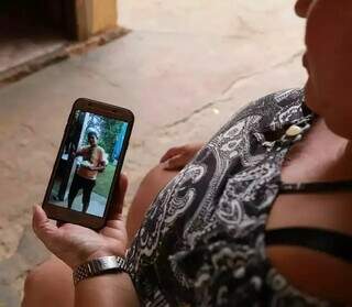 Mãe da vítima olhando foto do filho. (Foto: Kísie Ainoã)
