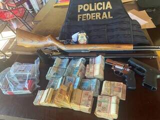 Armas, munições e dinheiro apreendidos em fazenda no município de Deodápolis. (Foto: Divulgação)