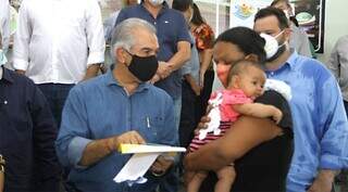 Governador Reinaldo Azambuja (PSDB) entrega cartão do programa a sul-mato-grossense. (Foto: Saul Schramm)