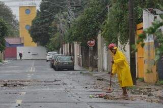 Após dia chuvoso e de ventania, homem varre a rua de casa. (Foto: Marcos Maluf)