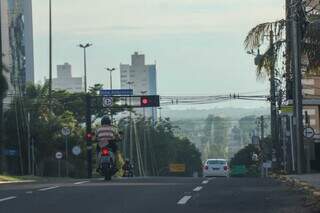 Sol aparece entre nuvens nos altos da Avenida Afonso Pena, na Capital. (Foto: Henrique Kawaminami)