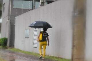 Mulher se protegendo de chuva na Capital esta semana. (Foto: Marcos Maluf)