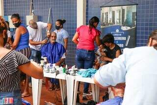 Moradores aproveitando o corte de cabelo gratuito (Foto: Henrique Kawaminami)