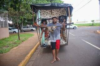 Sidnei carregando o carrinho com as crianças. (Foto: Paulo Francis)