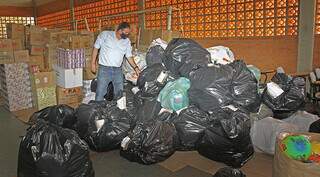 Eduardo Rocha em meio aos sacos e caixas de brinquedos. (Foto: Saul Schramm | Governo de MS)