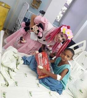 Lucimara entrega presente a um dos meninos hospitalizados. (Foto: Arquivo Pessoal)
