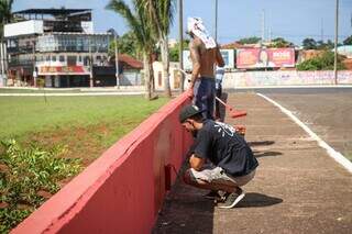 Matheus com outros dois ajudantes nesta tarde pintando o lado interno do viaduto. (Foto: Henrique Kawaminami)