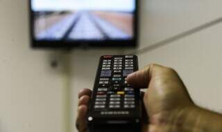 Telespectador usa controle remoto para trocar canal de TV (Foto: Agência Brasil)