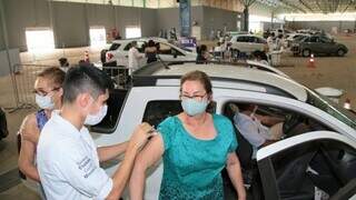 Passageira de carro é vacinada contra covid em drive-thru da Capital. (Foto: PMCG)