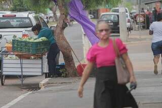 De máscara, mulher caminha nas ruas do comércio de Ribas. (Foto: Marcos Maluf)