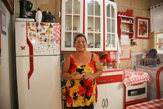 Dona Mireta, em sua cozinha pequena, mas cheia de amor e vermelho por todo lado. (Foto: Paulo Francis)