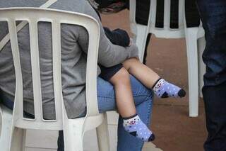 Mãe segura filho em triagem de pacientes com sintomas gripais na UPA do Coronel Antonino. (Foto: Marcos Maluf)