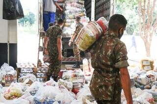 Militares do Exército carregam caminhão com alimentos (Foto: Henrique Kawaminami)