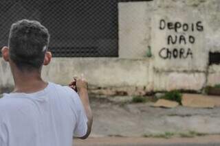 Thiago apontando para pichação de &#34;Depois não chora&#34; em um dos muros. (Foto: Marcos Maluf)