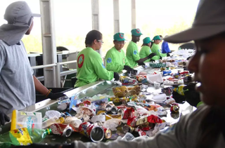 Trabalhadores manuseiam materiais em esteira de Unidade de Tratamento de Recicláveis em Campo Grande. (Foto: Arquivo/Campo Grande News)