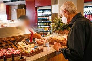 Homem realizando pagamento de compras em padaria de Campo Grande. (Foto: Arquivo/Kísie Ainoã)
