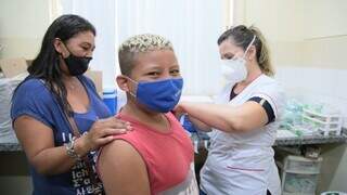 Menino sendo imunizado contra covid-19 em Campo Grande. (Foto: Divulgação | PMCG)