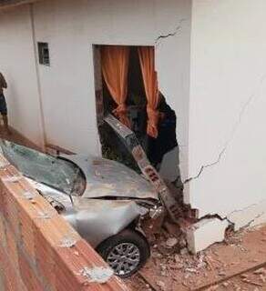 Carro foi parar dentro de residência após derrubar muro. (Foto: Polícia Militar)