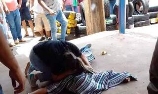 Mulher chora debruçada sobre corpo de homem executado na manhã de hoje. (Foto: Direto das Ruas)