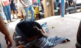 Mulher chora debruçada sobre corpo de homem executado na manhã de hoje. (Foto: Direto das Ruas)