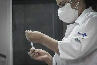 Funcionária arrumando dosagem da vacina na seringa. (Foto: Marcos Maluf)