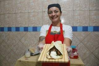 Marina segura lanche feito com pão sírio e isca de carne. (Foto: Paulo Francis)