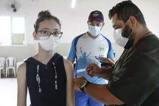 Menina recebendo dose de vacina contra covid-19 em Mato Grosso do Sul. (Foto: Divulgação)