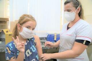 Menina recebe primeira dose de vacina contra covid em Campo Grande (Foto: Divulgação)