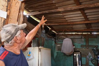 Sebastião Neckel Paranhos mostra teto que já foi destelhado por vento (Foto: Henrique Kawamimnami)