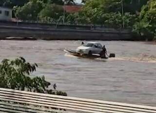 Por causa da cheia, um ribeirinho teve que transportar o carro em duas lanchas para conseguir chegar à margem do Rio Taquari. (Foto: Reprodução/Vídeo)