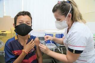 Menino sendo imunizado com a primeira dose da vacina (Foto: Divulgação | PMCG)