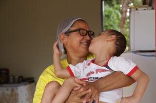 Dona Adriana, segurando o neto Yago nos braços, hoje sua maior força para viver. (Foto: Kísie Ainoã)