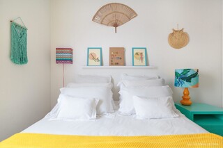 Opção de quarto branco com peseira amarela, quadros e criado-mudo coloridos. (Foto: Pinterest)