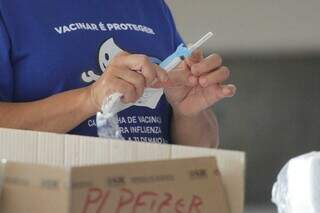 Profissional de saúde manuseia seringa para aplicação de dose da vacina. (Foto: Marcos Maluf)